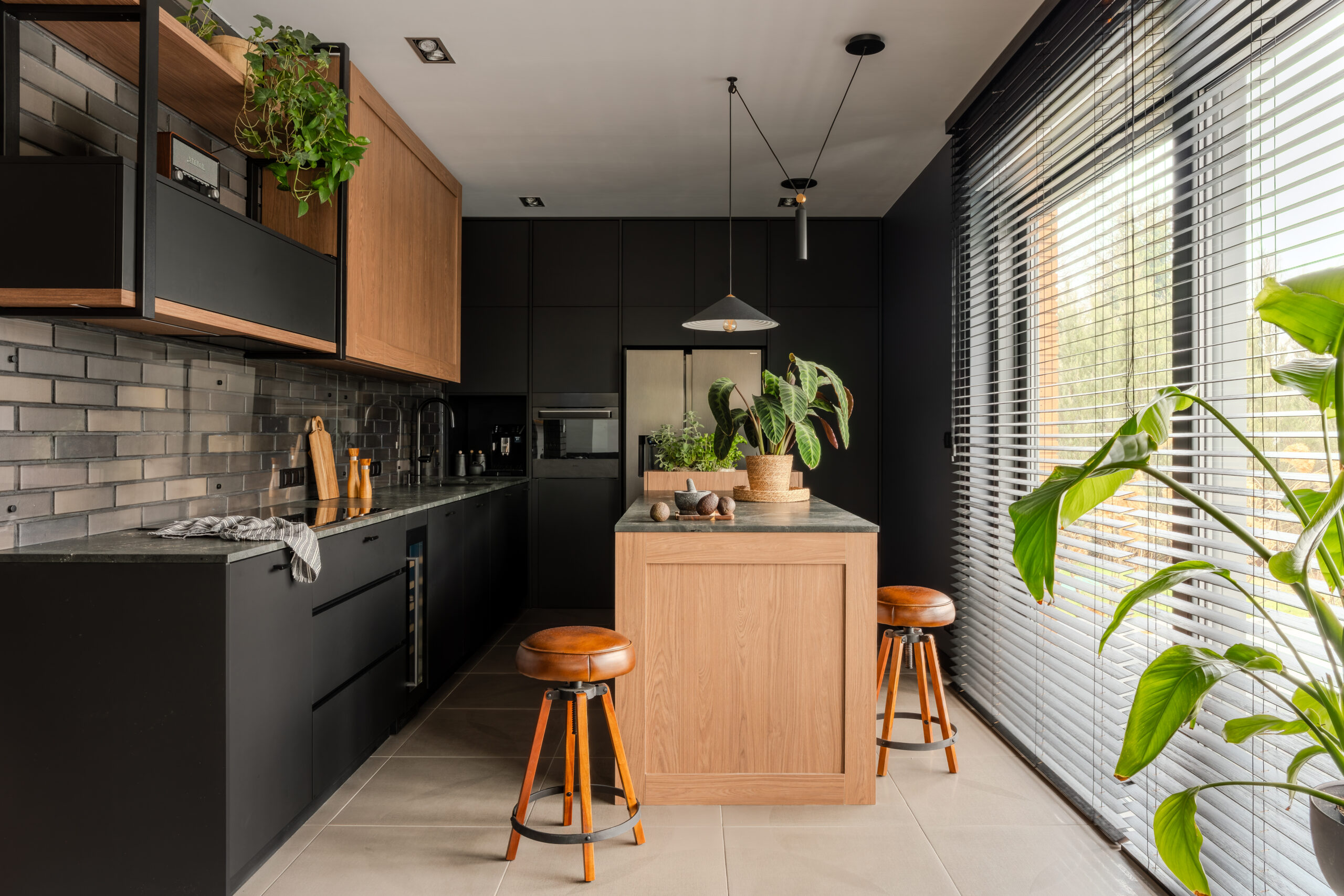 Mieszkanie w naturalnym stylu z otwartą kuchnią i jadalnią. Ciepłe drewniane podłogi, beżowe i oliwkowe akcenty oraz naturalne tkaniny tworzą przytulną atmosferę. Designerskie krzesła i oświetlenie podkreślają elegancki, harmonijny wystrój wnętrza.