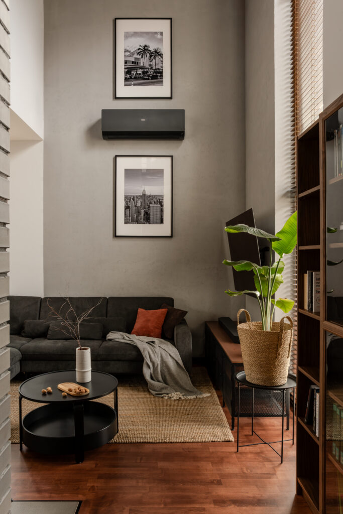 Industrialny dom – detal salonu z regałem, roślinami i industrialnymi materiałami wykończeniowymi.